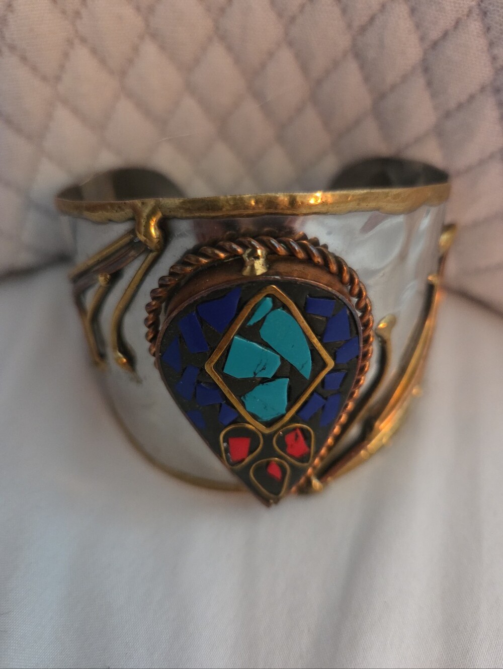This Multi Tone Hammered Metal Cuff Bracelet features teardrop shaped turquoise